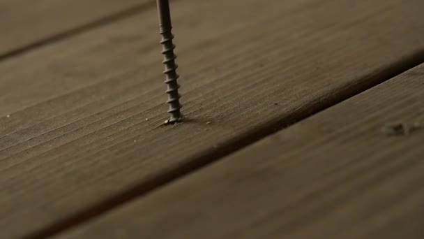 Carpenter corrigeert de houten vloer met schroeven met een schroevendraaier. Slow Motion — Stockvideo