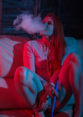 Seksi kızıl saçlı kadın kırmızı mavi tonları elektronik nargile vaping