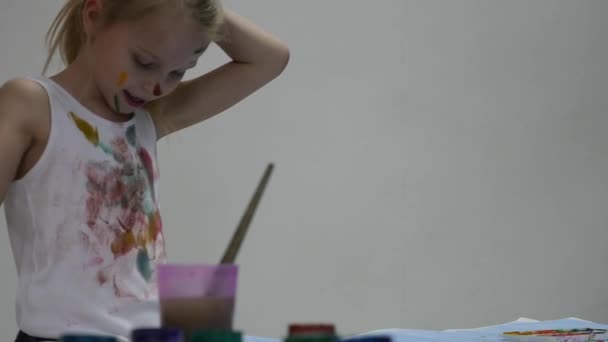 Ξανθιά μικρή μαθήτρια ζωγράφος ζωγραφίζει τον εαυτό του και τα ρούχα της. αργή κίνηση — Αρχείο Βίντεο