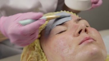 güzellik spa salonunda kadın yüzü için çamur maskesi uygulayarak. yüz gençleştirme prosedürü, spa tedavileri