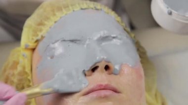 güzellik spa salonunda kadın yüzü için çamur maskesi uygulayarak. yüz gençleştirme prosedürü, spa tedavileri