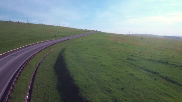 Vol aérien au-dessus de la route à travers les collines, vol à basse altitude. 4K — Video