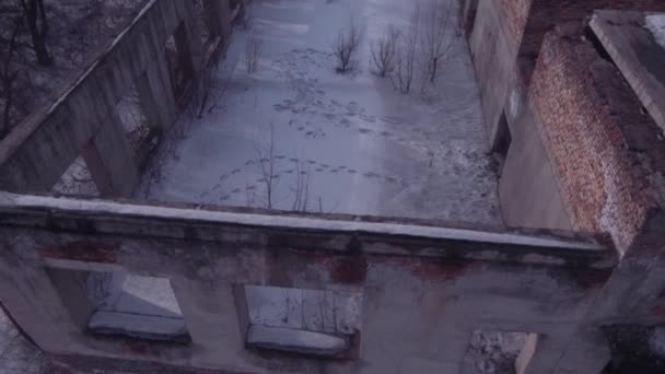 Політ над покинутою будівлею, стара зруйнована будівля в зимовий сезон. Вид з повітря 4K — стокове відео