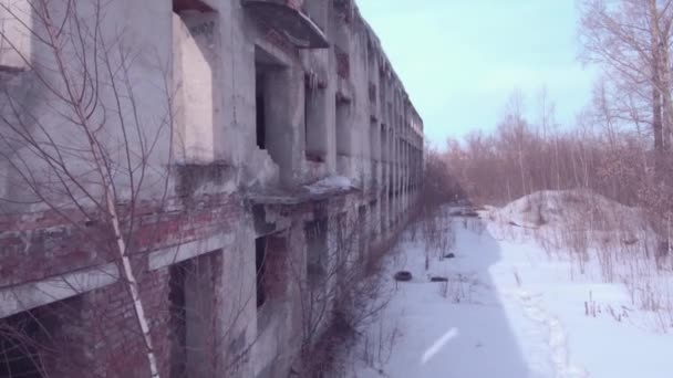 Terk edilmiş binanın üzerinden uçarken, eski bir kış mevsiminde yıkılan bina. Havadan görünüm 4k — Stok video