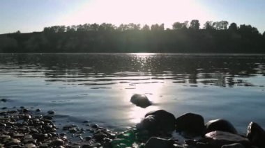 geniş sığ nehirhızlı akış, su ile alt kısmında bir taş görünümü. su üzerinde güneş parlama