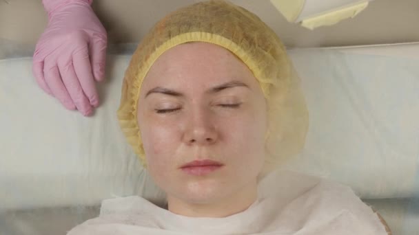 El médico limpia la piel de las mujeres con vapor. mujer joven con problemas de piel en la esteticista. Concepto de cosmetología. 4K — Vídeo de stock