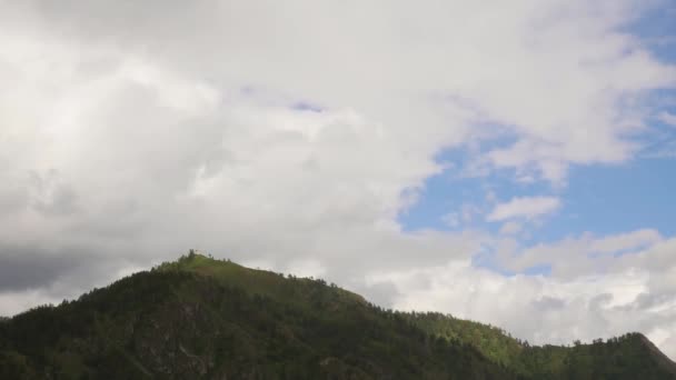 Bela vista do vale da montanha com nuvens rolando rápido à deriva sobre pequena capela no topo de uma montanha. Prazo de validade — Vídeo de Stock