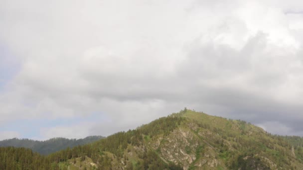 Piękny widok na dolinę górską z szybkimi chmurami toczenia się nad małą kaplicą na szczycie góry. Timelapse — Wideo stockowe