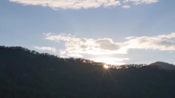 Puesta de sol sobre las montañas, las nubes de la tarde se alejan rápidamente. lapso de tiempo — Vídeos de Stock