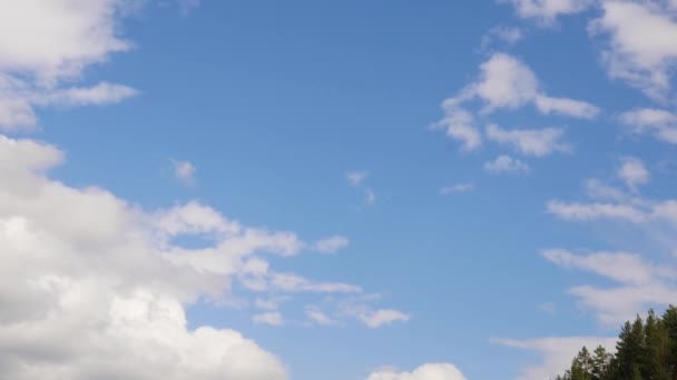 Mavi gökyüzünde beyaz bulutlar dolaşıyor, yuvarlanan kabarık bulutlar bir yaz günü hareket ediyor. — Stok video