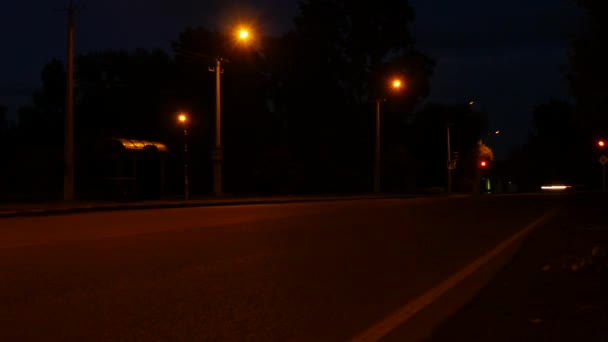 Luces de coche en la noche en un cruce con semáforo, poco tráfico en un cruce de autopistas — Vídeos de Stock