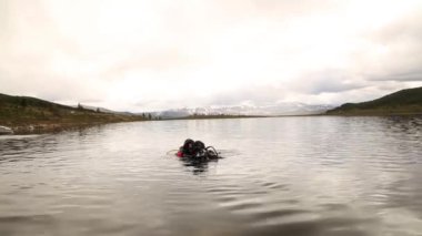 bir dağ gölünde tüplü dalış, acil kurtarma için teknikler pratik. soğuk suya daldırma