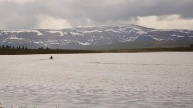 motorlu tekne dağlarda yürüyüş ve balıkçılık, bir dağ gölü üzerinde yüzer