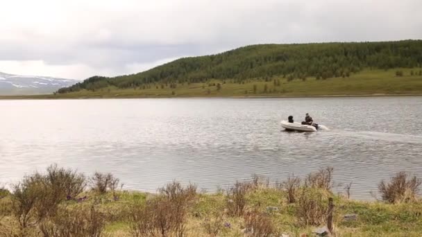 Motorbåten flyter på en fjällsjö, vandring och fiske i fjällen — Stockvideo