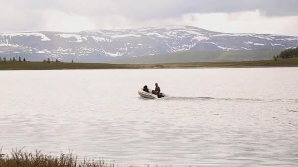 Kapal bermotor mengapung di sebuah danau pegunungan, mendaki dan memancing di pegunungan — Stok Video