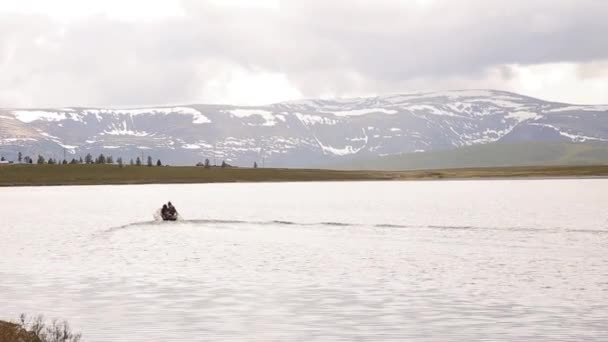 Motorbåten flyter på en fjällsjö, vandring och fiske i fjällen — Stockvideo