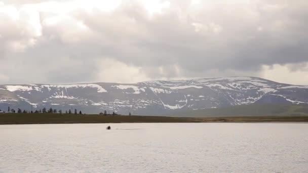 Motorlu tekne dağlarda yürüyüş ve balıkçılık, bir dağ gölü üzerinde yüzer — Stok video
