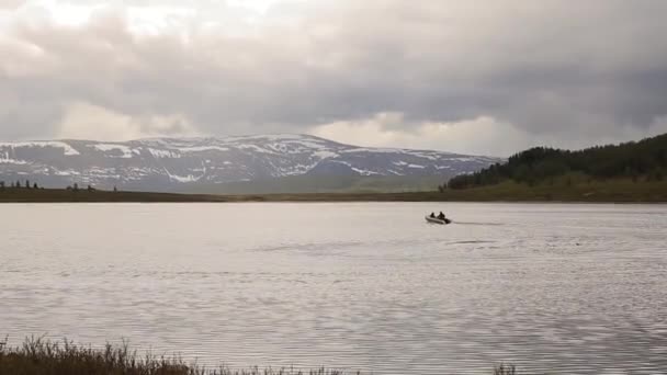 Моторная лодка плавает на горном озере, пешие прогулки и рыбалка в горах — стоковое видео