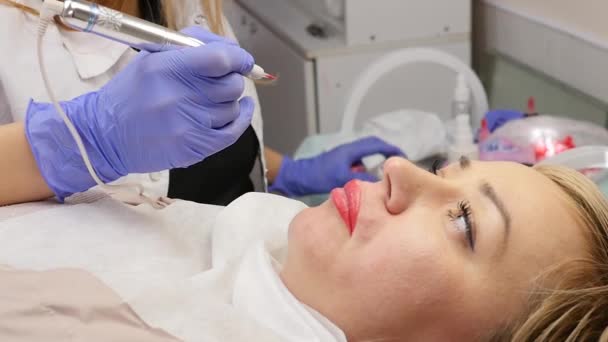 Ο γιατρός αισθητικός κάνει τη διαδικασία του μόνιμου μακιγιάζ για τα χείλη των γυναικών πελατών. αργή κίνηση — Αρχείο Βίντεο