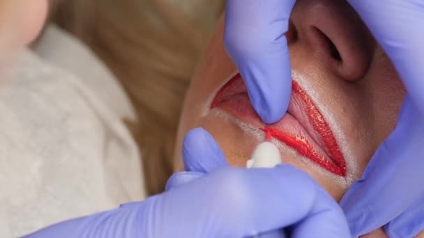 Tratamiento labial de primer plano. procedimiento de maquillaje permanente para los labios del cliente femenino — Vídeo de stock