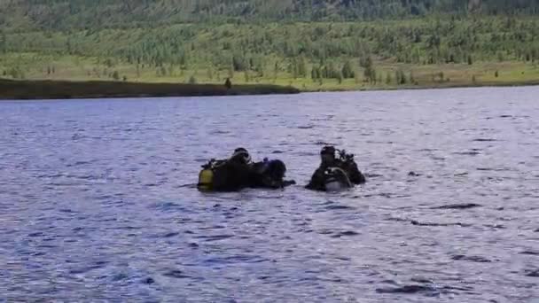 Dykning i en fjällsjö, öva tekniker för räddningspersonal räddare. nedsänkning i kallt vatten — Stockvideo