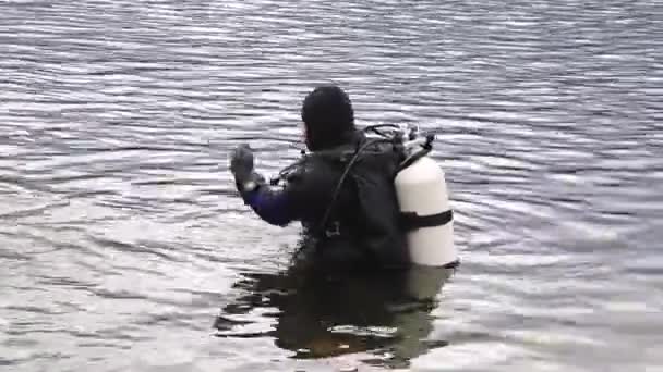Ныряльщик с аквалангом входит в воду горного озера. Практикует технику для спасателей. погружение в холодную воду — стоковое видео