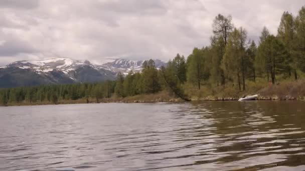 Vue timelapse d'un lac de montagne avec nuages orageux reflétés dans une surface d'eau 