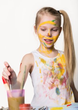 Sevimli küçük kız ressam masanın üzerine çizer ve giysilerini kendini. yavaş çekim