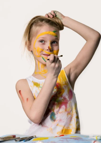 小女学生可爱的小女孩画家画在桌子上,自己在她的衣服上。慢动作 — 图库照片