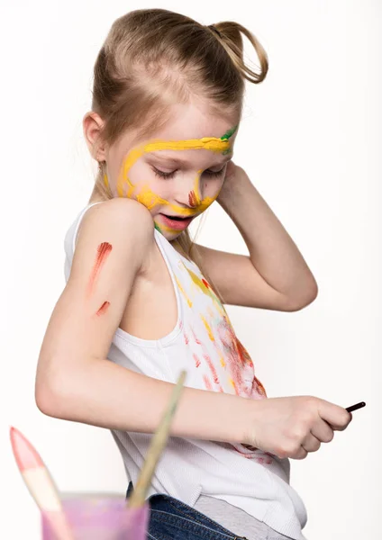 Bonito pintor menina desenha sobre a mesa e sobre si mesmo em suas roupas. câmara lenta — Fotografia de Stock