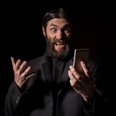 Bir akıllı telefon ile eski mümin Kıdemli Rahip, sakallı yaşlı adam karanlık bir arka planda çağırıyor