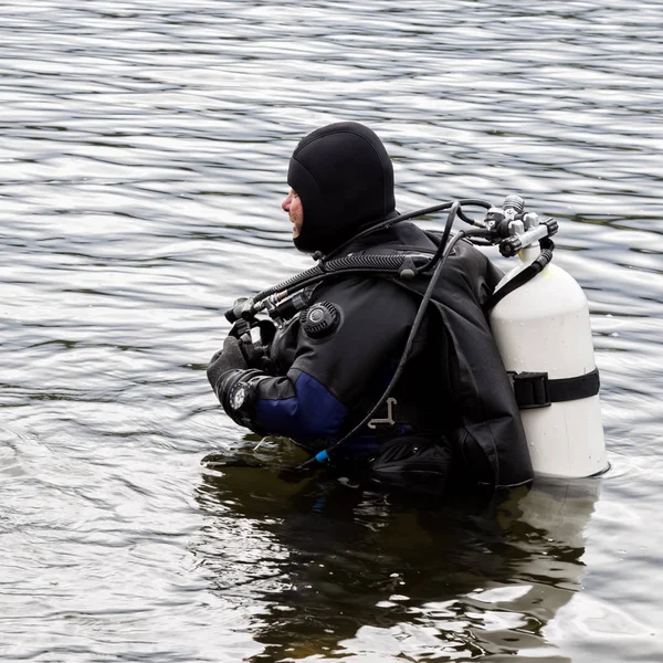 Buceador entra en el agua del lago de montaña. practicar técnicas para socorristas de emergencia. inmersión en agua fría — Foto de Stock