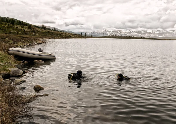 Scufundări într-un lac de munte, practicând tehnici pentru salvatorii de urgență. scufundare în apă rece fotografii de stoc fără drepturi de autor