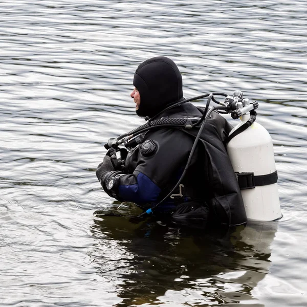 潜水员进入山湖水。练习紧急救援者的技术。浸泡在冷水中 图库图片