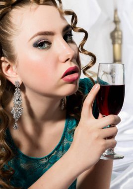 gizemli genç kıvırcık kadın yatakta istirahat ve kırmızı şarap içiyor