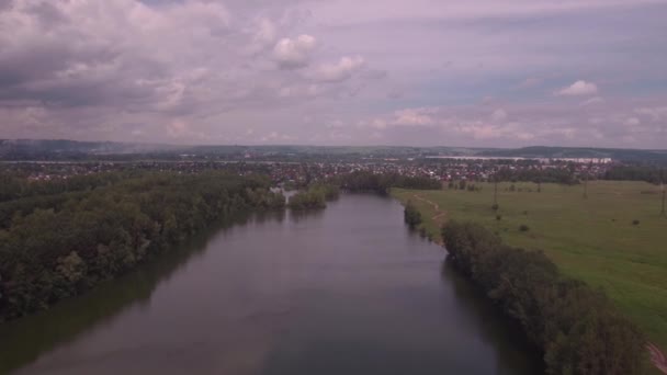 Vista aerea. Basso volo sul lago alla soleggiata mattina d'estate. Alberi verdi e colline, riflesso di nuvole sulla superficie del lago. 4K — Video Stock