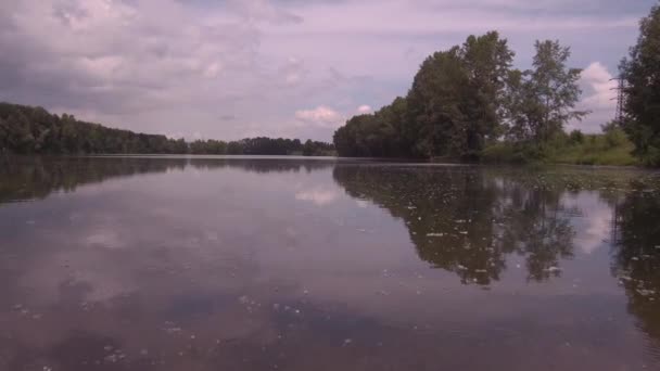 Luchtfoto. Lage vlucht over het meer bij zonnige zomer ochtend. Groene bomen en heuvels, reflectie van wolken op het meer oppervlak. 4k — Stockvideo