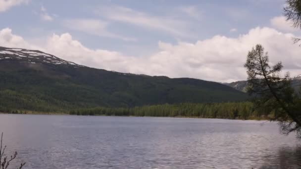 Vue d'un lac de montagne avec nuages orageux reflétés dans une surface d'eau. forêt de conifères sur le rivage 