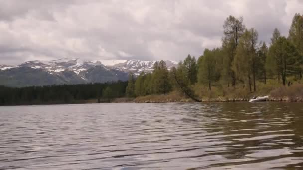Vue d'un lac de montagne avec nuages orageux reflétés dans une surface d'eau. forêt de conifères sur le rivage 