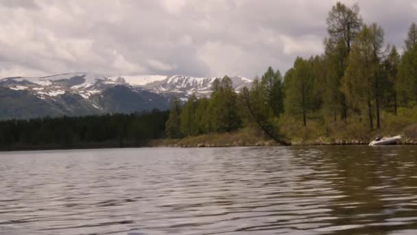 Vue d'un lac de montagne avec nuages orageux reflétés dans une surface d'eau. forêt de conifères sur le rivage — Video