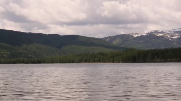 Kilátás a hegyi tó viharfelhők tükröződik a vízfelszín. tűlevelű erdő a parton — Stock videók