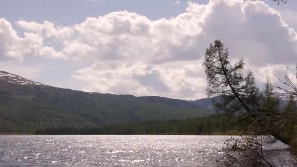 Vista del lago di montagna con nuvole temporalesche riflesse in una superficie d'acqua. foresta di conifere sulla riva — Video Stock