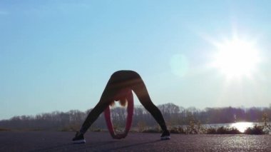 gün doğumu veya gün batımı sırasında egzersiz ler yapan atletik kadın. nehir kıyısında sportif kız