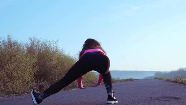 Die sportliche Frau treibt bei Sonnenaufgang Sport am Ufer des Flusses. Zeitlupe — Stockvideo