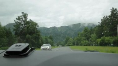 bir bulutlu bahar sabahı araba sürücü sırasında ön cam ile Dağlık görünümü. Highland altay pitoresk kır yolları