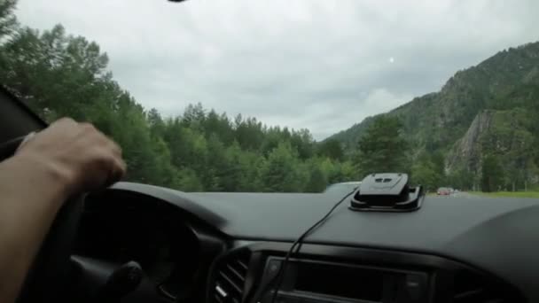 Widok na wyżyny przez przednią szybę. deska rozdzielcza i kierownica z rękami kierowców, poranną mgłą na górach — Wideo stockowe