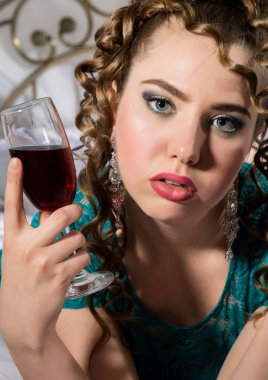 bir otel odasında yatakta istirahat ve kırmızı şarap zevk güzel genç kıvırcık kadın