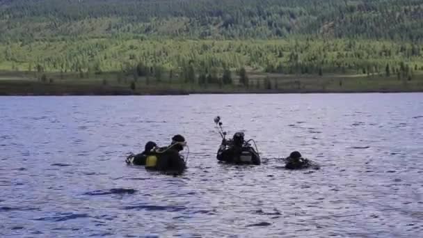 山の湖でスキューバダイビング、緊急救助のための技術を練習。冷たい水に浸る — ストック動画
