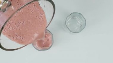 susam ile meyve meyvesi kokteyli pişirmek, bir mikser malzemeleri karışımları. sağlıklı kahvaltı servis edilmektedir. üst görünüm. 4k
