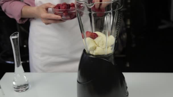 Жінка готує фруктовий ягідний коктейль з кунжутом, змішує інгредієнти в мікшер. здоровий сніданок . — стокове відео